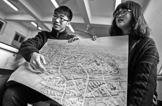 昨天上午，在beat365英国官方网站，手绘图的作者郭龙(左)和何菡丹(右)在展示他们的创作手稿。 记者 姚卡/摄